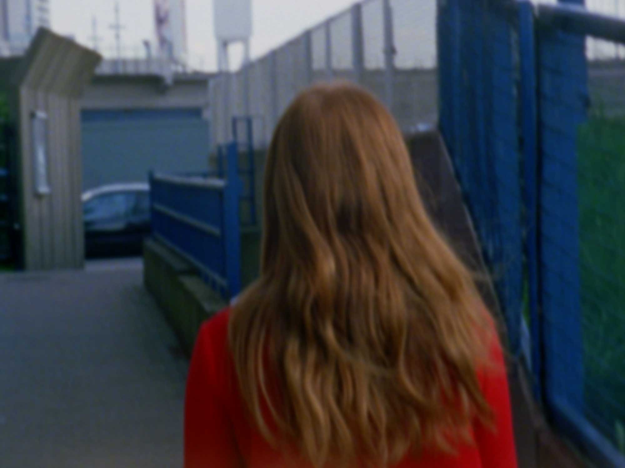Film still: a woman dressed up as Veruca Salt walking in an East London neighbourhood