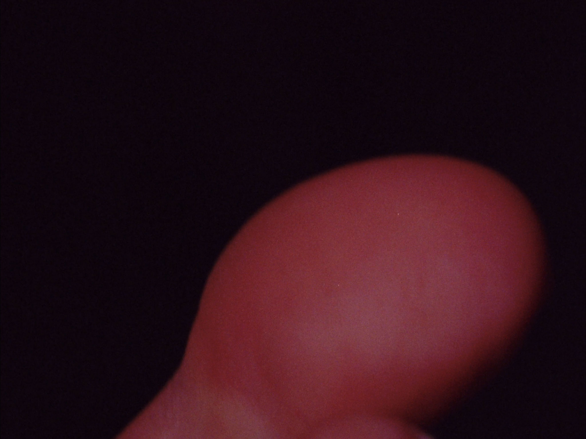 16mm film still: a big toe over a black background